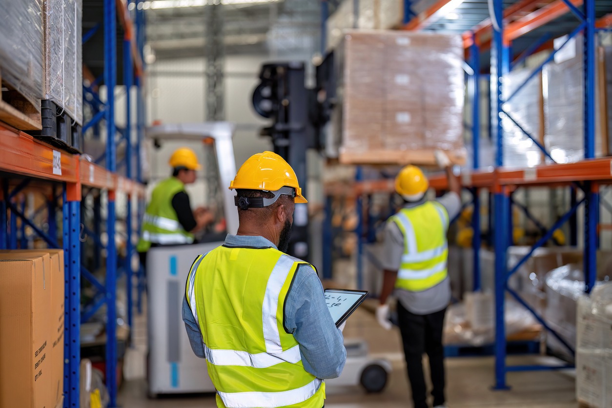 African american working in warehouse hold red light give signal to truck loading carton box